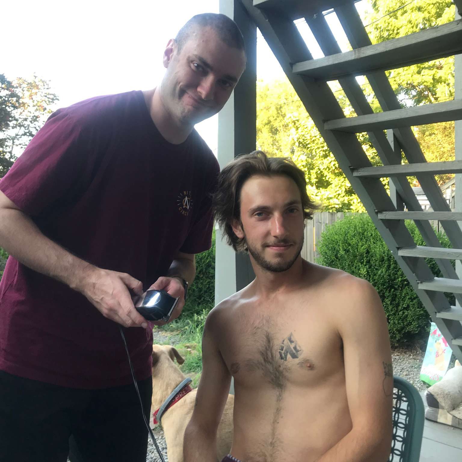 Stevene preparing to shave his friend's head